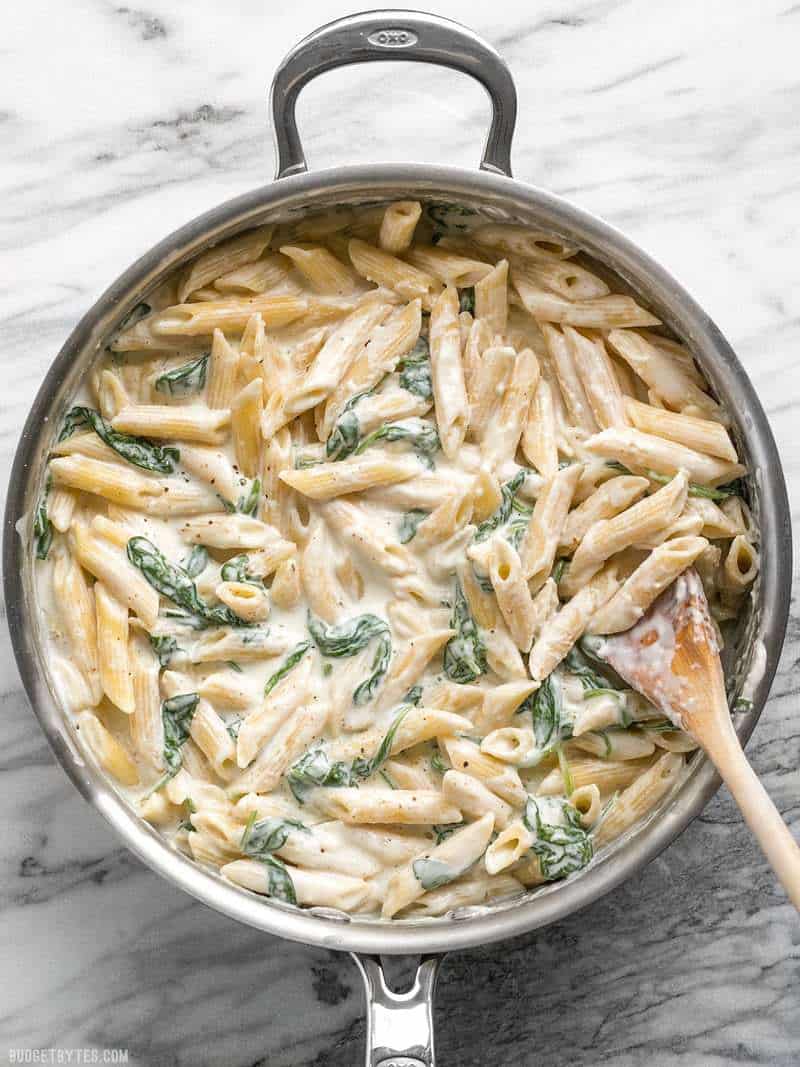 Creamy and rich, yet never heavy, this Lighter Spinach Alfredo Pasta is an easy and satisfying comfort food. Perfect for busy weeknight dinners! Budgetbytes.com A pan full of easy and delicious "lighter" Spinach Alfredo Pasta